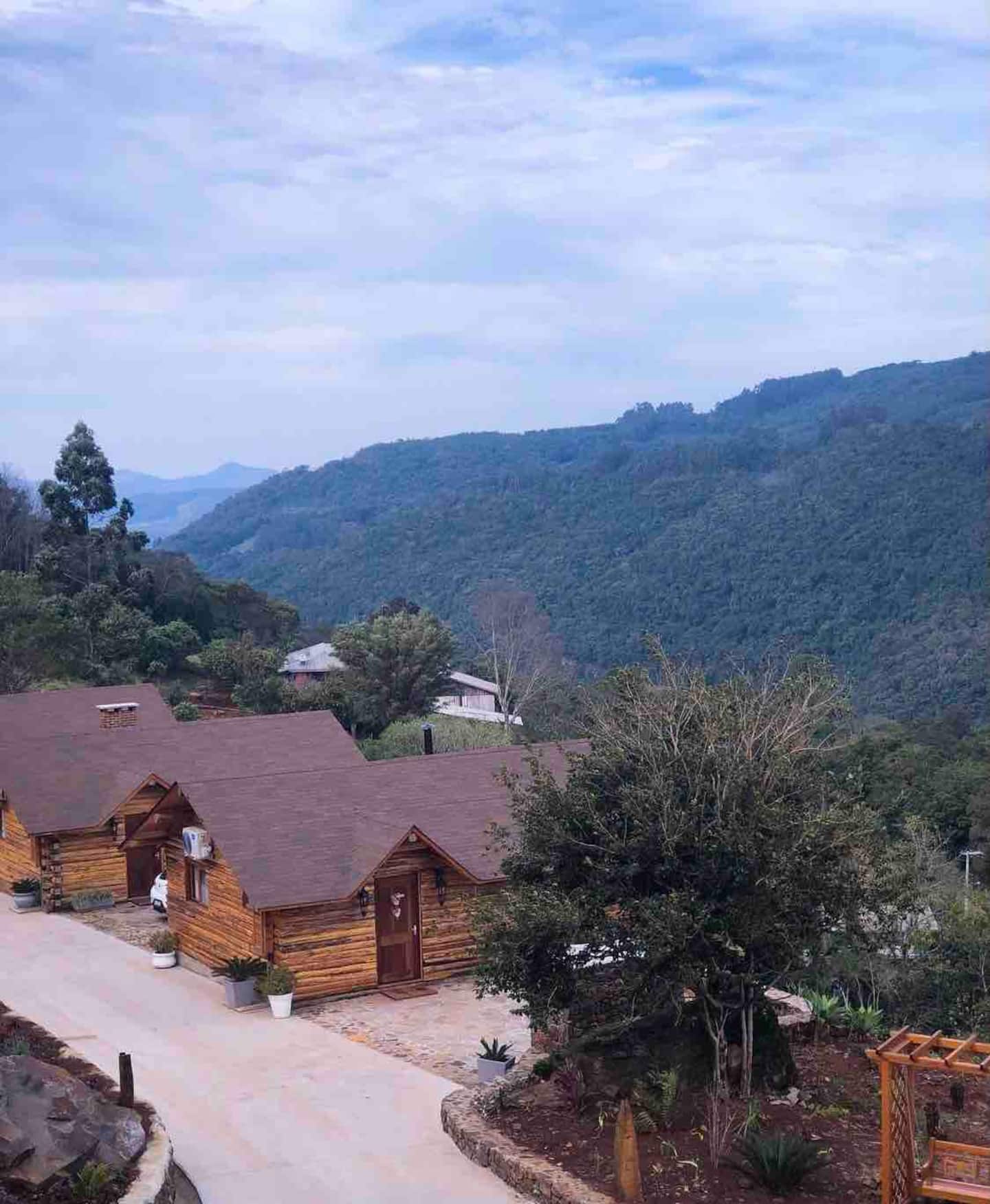 Conjunto de cabanas de madeira com a serra ao fundo